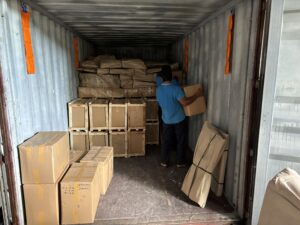 The staff of Bali Cipta Mandiri Cargo is stuffing the customer's goods into the container